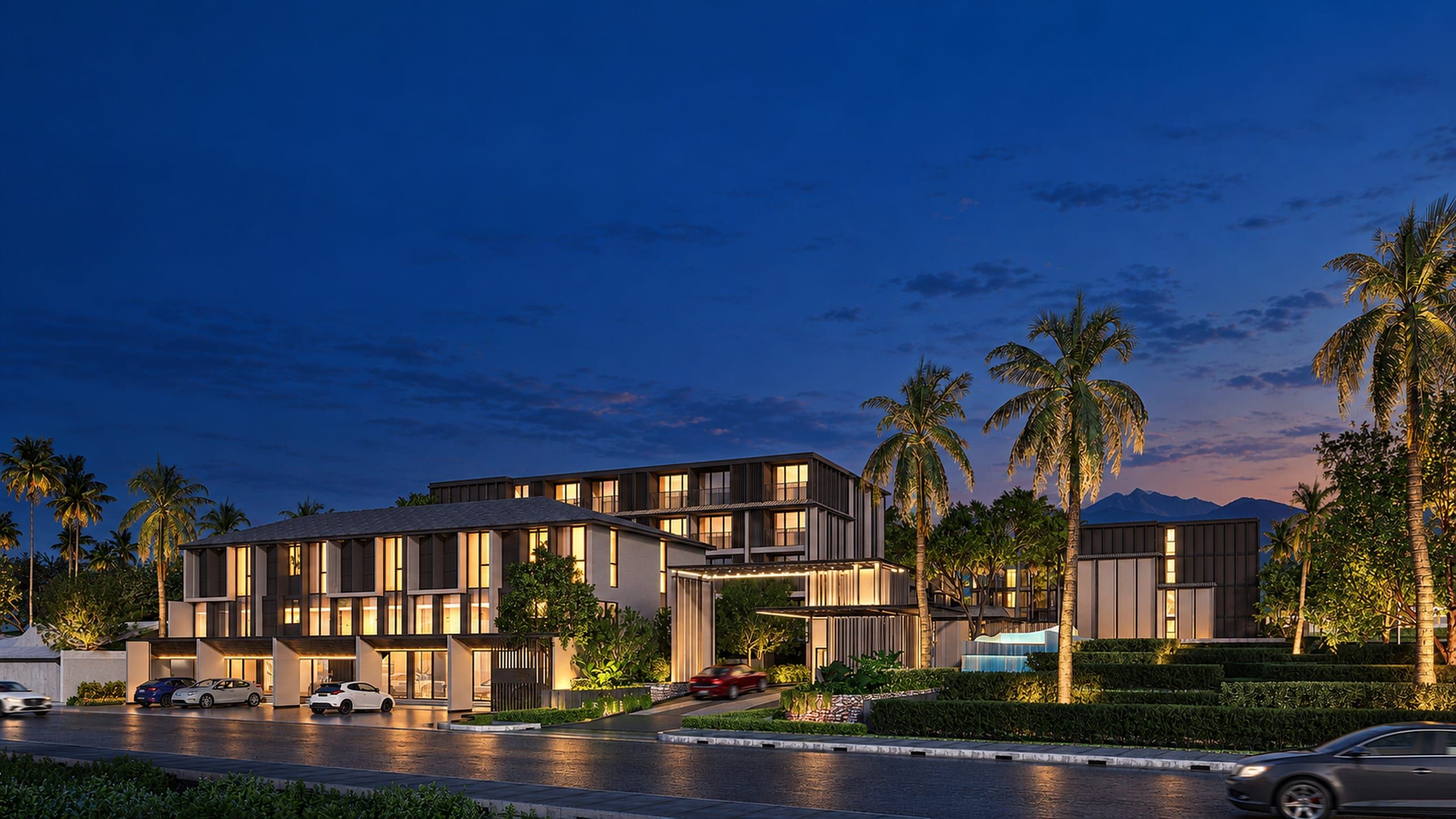 Street view of a low residential complex with a two-storey wing, taller blocks behind, palms and mountains in the distance, visualisation